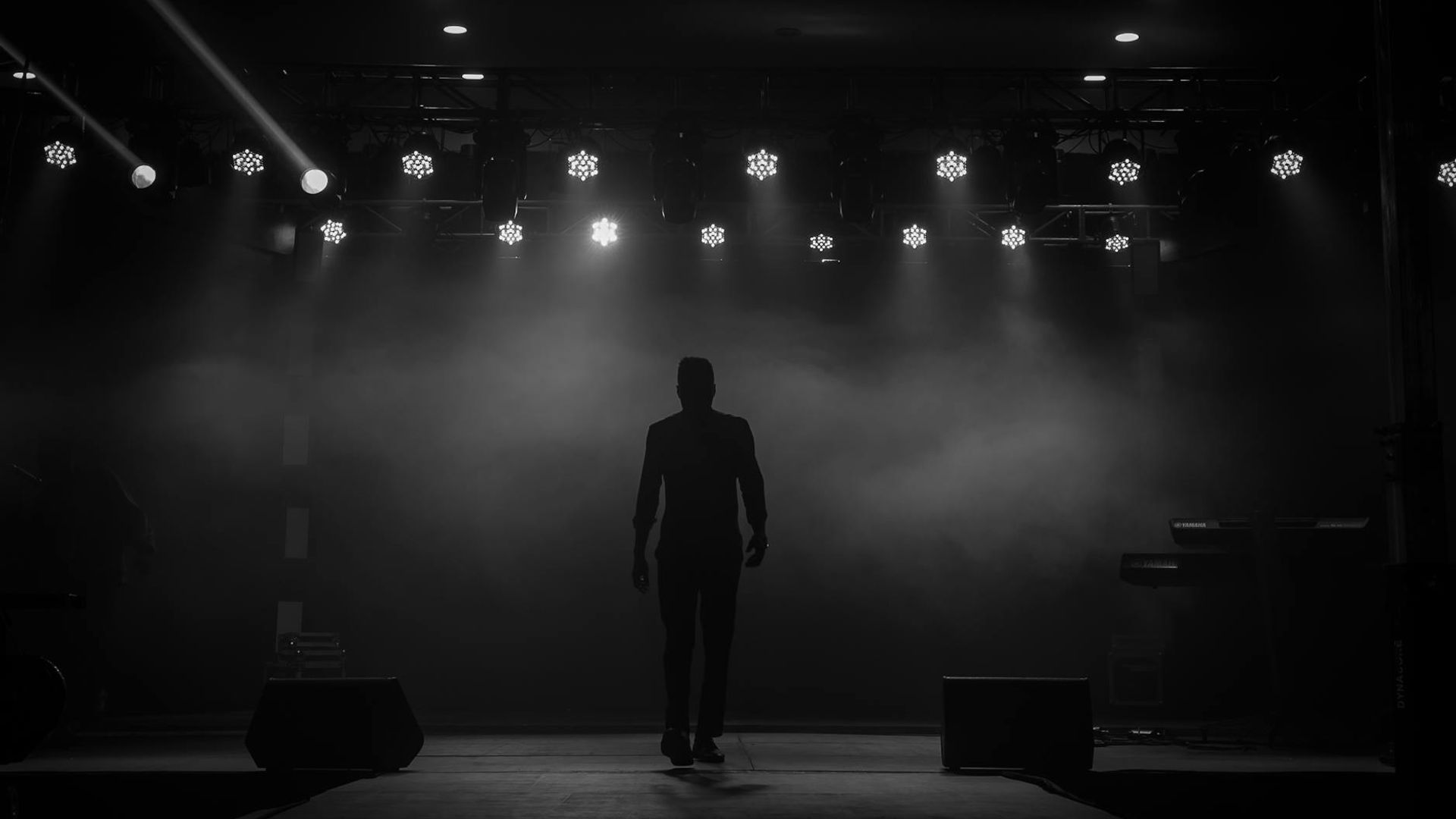 Silhouette of a man in a powerful stance against a dark, atmospheric background.